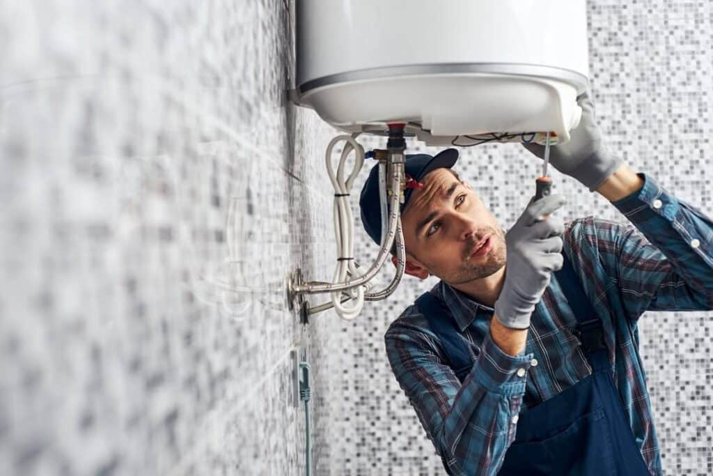 plumber inspecting water heater for repair